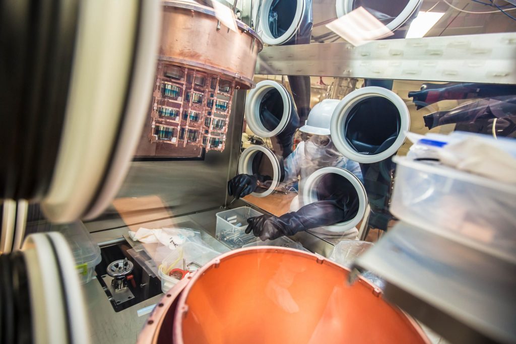 UNC-Chapel Hill physics and astronomy professor John Wilkerson installs the germanium detector strings into the cryostat. The machine is part of the MAJORANA Demonstrator, which is used to detect and study neutrinos at the Sanford Underground Research Facility in Lead, South Dakota. Photo by Matthew Kapust