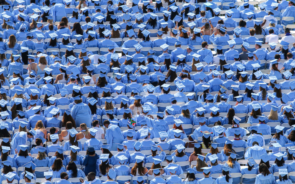 Photo shows a sea of Carolina blue graduation caps and gowns in the Kenan Stadium at the commencement 2018 ceremony.