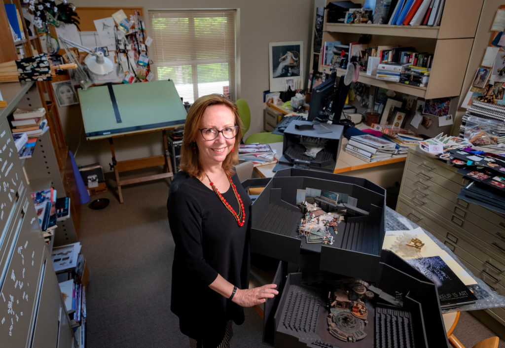 Jan Chambers is a professor in the department of dramatic art and a resident designer for PlayMakers Repertory Company. (photo by Jon Gardiner) She stand here in her office in front of some of her scenic design mockups.