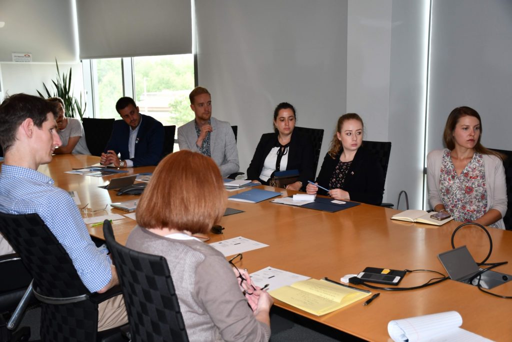 A delegation from the U.S. Department of State International Visitor Leadership Program on foreign policy sit in a FedEx Global Education Center conference room to listen to a panel of Carolina faculty members.