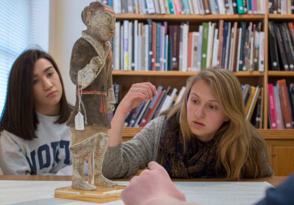 Two students look at an artifact from the Ackland Art Museum for a QEP class.