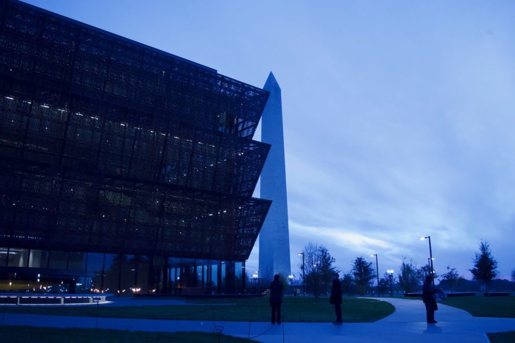 Students in Glenn Hinson's "Descendants Project" class interviewed three generations of descendants of Warren County lynching victims at the National Museum of African American History and Culture in Washington, D.C. (photo by Hannah Evans) (photo shows a night-time view of the museum with the Washington Monument in the background).