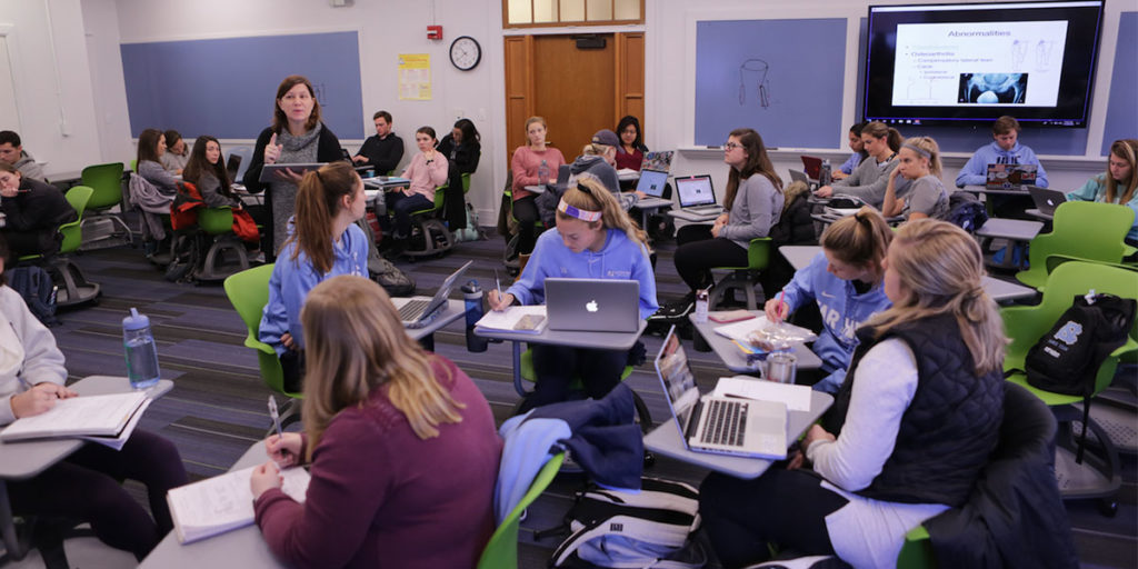 Teaching professor Meredith Petschauer in the exercise and sports science department uses her finger to write notes on a tablet that students in her Biomechanics of Sports class can see on TV screens throughout the flexible classroom in Woollen Gym. (Photo courtesy of Lars Sahl, OASIS)