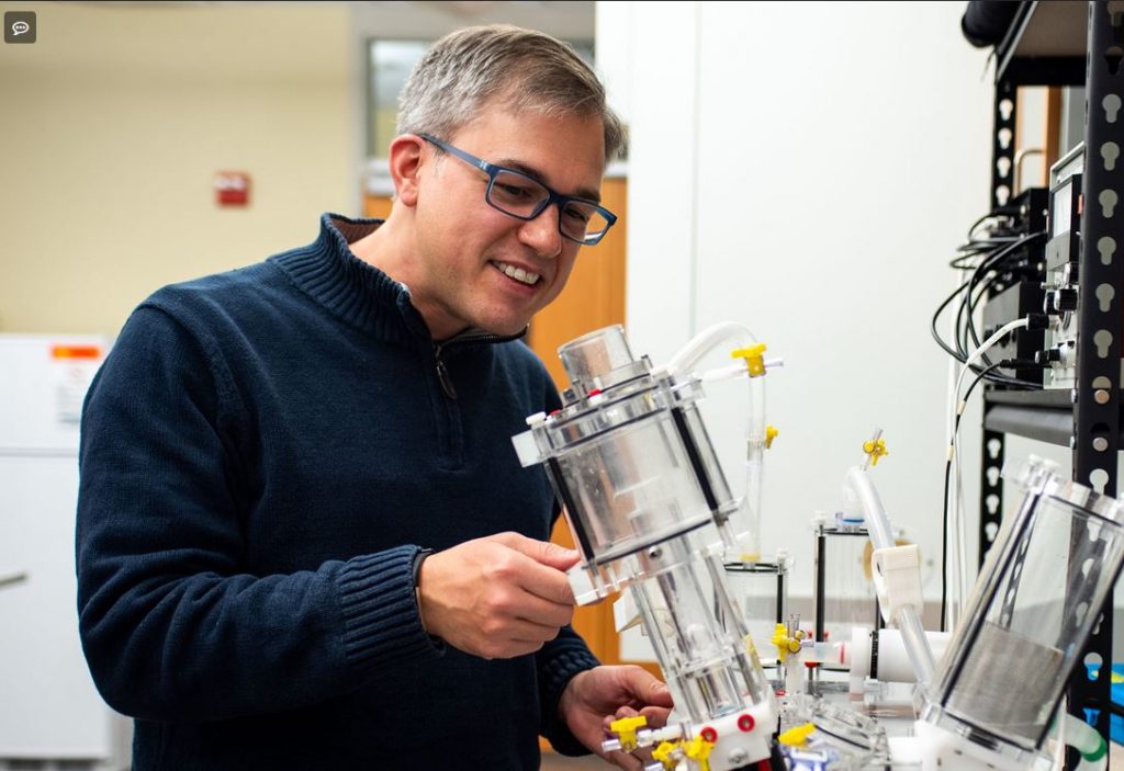 Boyce Griffith adjusts a pulse duplicator, which can test the performance of artificial heart valves in different flow conditions. (photo by Liah McPherson)