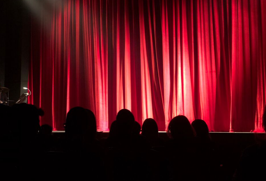 stage with red curtain illustrates performance