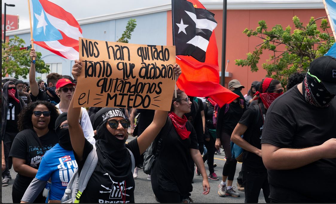 Another sign reads: "They've taken so much from us that they ended up taking away our fear."