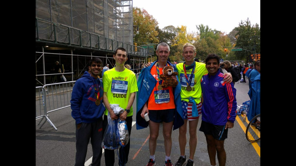 Ethan Lievense (second from right in the USA shorts) helped Tony Ward (center, in the orange T-shirt) run the New York City Marathon.