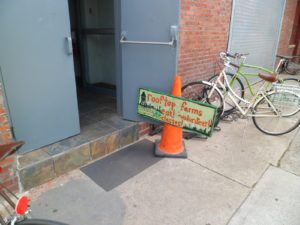 This sign at the bottom of a warehouse led Kate Grady three stories up to a magnificent rooftop garden. (photo by Kate Grady)