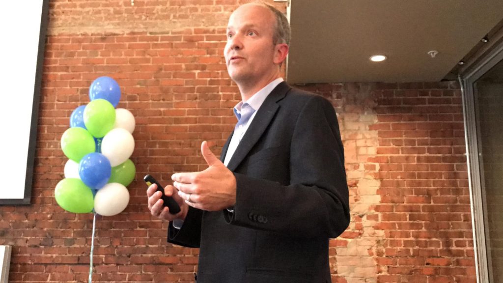 Mark Schoenfisch was named UNC-Chapel Hill Inventor of the Year. (he is shown her speaking at a podium at the awards event with balloons in the background.)