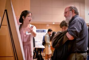 Chang Zhao, left, talks about her research to Michele Maynard, center, and Dale Hutchinson at the Celebration of Undergraduate Research at the University of North Carolina at Chapel Hill.