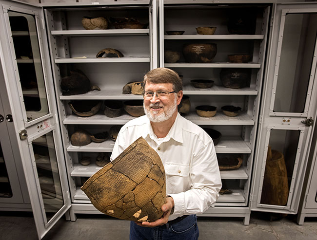 The reconstructed earthenware cooking pot held by archaeology professor Stephen Davis dates to A.D. 1000-1400. It was found along Morgan Creek in 1949, during a brief dig done before construction of Finley Golf Course.