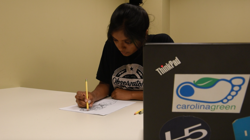 Superhero Project graphics director Lahari Pullakhandam sketches a superhero in the Undergraduate Library. The student organization aims to empower UNC Childrens Hopsital patients to be strong when they feel weak.