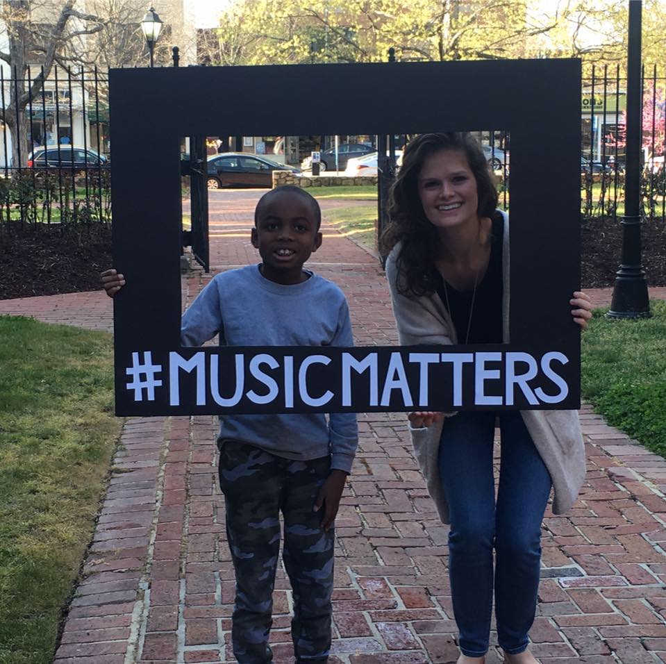 Carolina senior Lindsay Player has been giving piano lessons to Matthew for four years through the student organization Musical Empowerment. They are pictured here holding a sign that says "Music Matters."