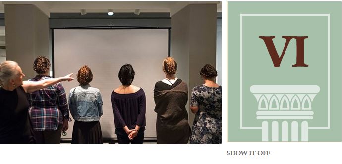 Five women stand at the front of the room with their backs to the camera, showing off the ornate braids on teh back of their heads.The caption reads: "Show it Off."