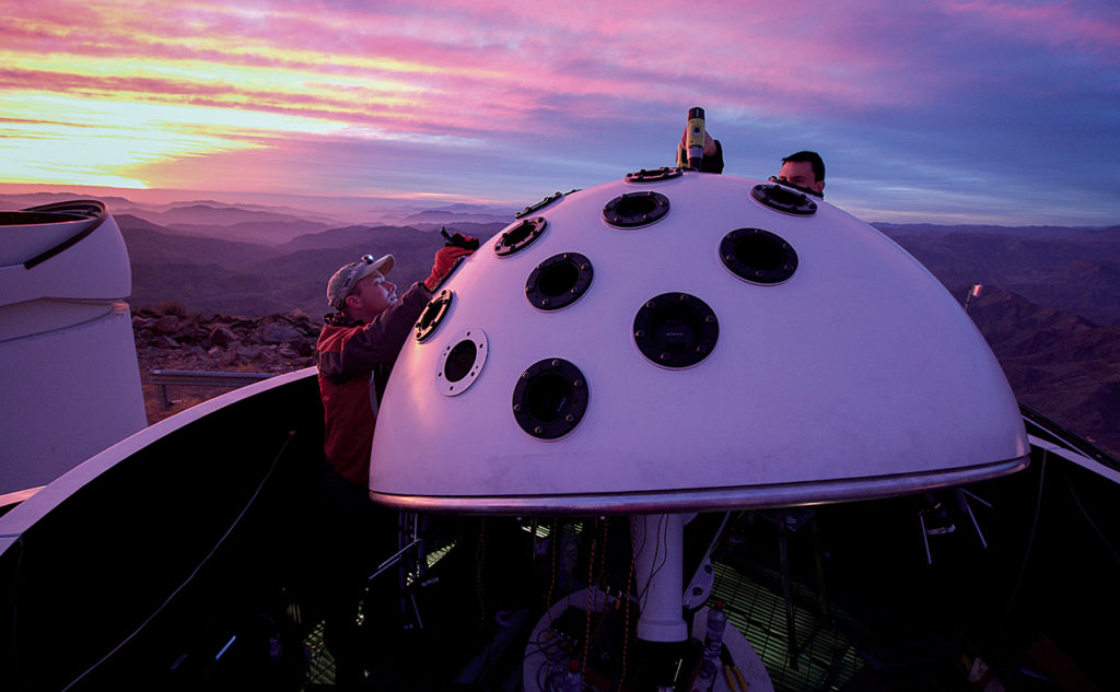 A picture of the Evryscope dome with a pink and lavendar sky in the background.