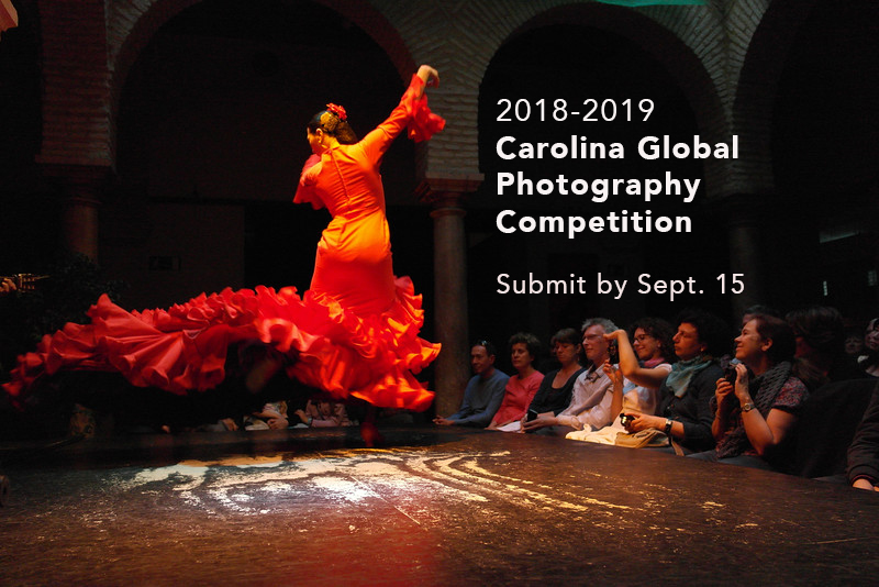 Photo shows a woman dancing, her back to the audience in an orange dress. From the photographer: "During a trip to seville, i attended a demonstration of traditional flamenco dancing and was awed by the vivacity and passion of the dance, which is communicated here by the motion of the dancer's twirling skirt and its fiery hue." The words "2018=2019 Carolina Global Photography Competition and Submit by Sept. 15" are written on the photo.