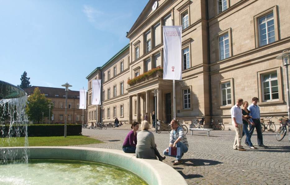 Carolina and Tubingen have operated an undergraduate student exchange since 1986. In that time, more than 100 undergraduate students have spent a semester or year at the partner university. This hpoto shows one of the campus buildings with students walking by and sitting near a water fountain.