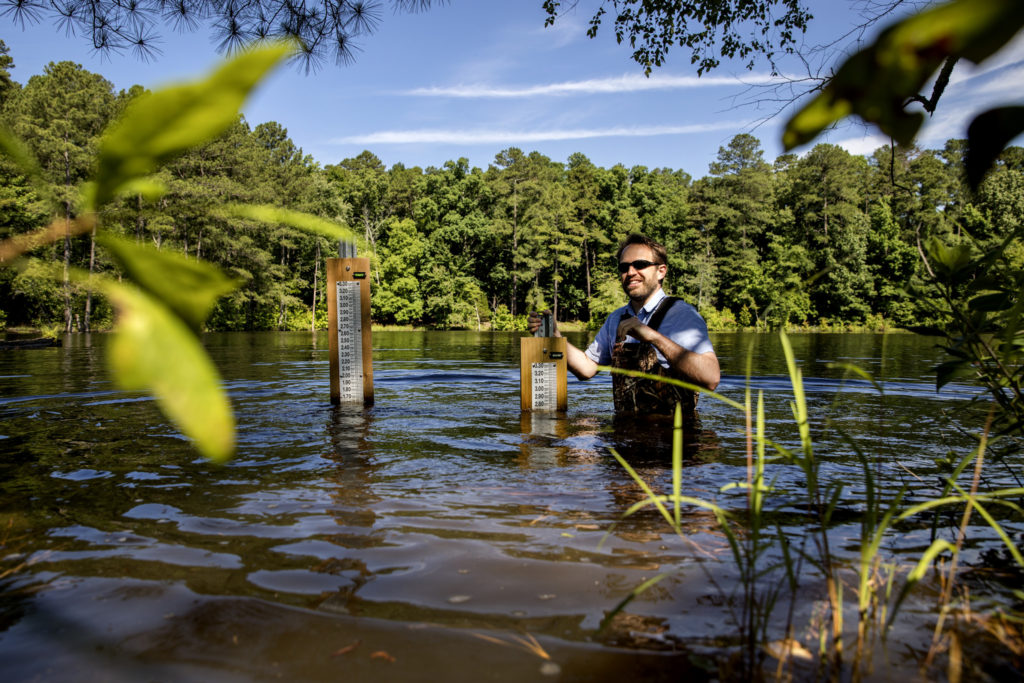 Tamlin Pavelsky, associate professor of geological sciences in the UNC Department of Geological Sciences, measures water levels at Botany Pond on June 9, 2017, in Chapel Hill. (photo by Johnny Andrews)