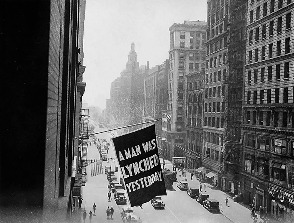 black and white photo of a flag saying "A man was lynched yesterday"