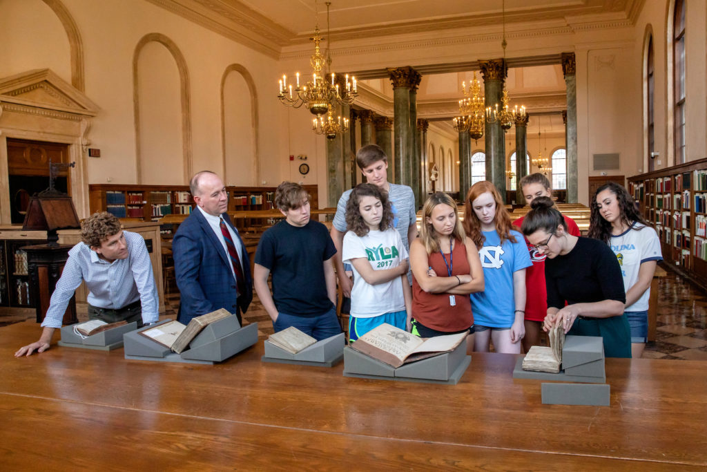 Liz Ott, the Frank Borden Hanes Curator of Rare Books, shows a collection of books and manuscripts to the class in the Fearrington Reading Room at Wilson Library. (photo by Johnny Andrews)