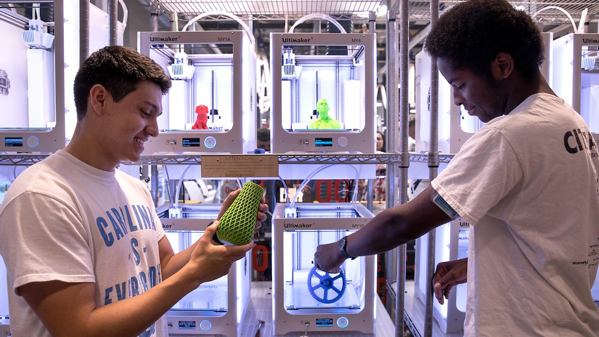 Nick Aguilar, left, a junior linguistics and German major from Charlotte, and sophomore Aydan Smith, right, of Atlanta work in the 3D printing area of the BeAM makerspace in Murray Hall. (photo by Johnny Andrews)
