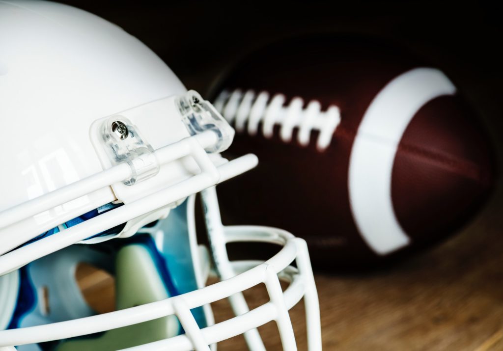 football helmet and football beside it (closeup photo)