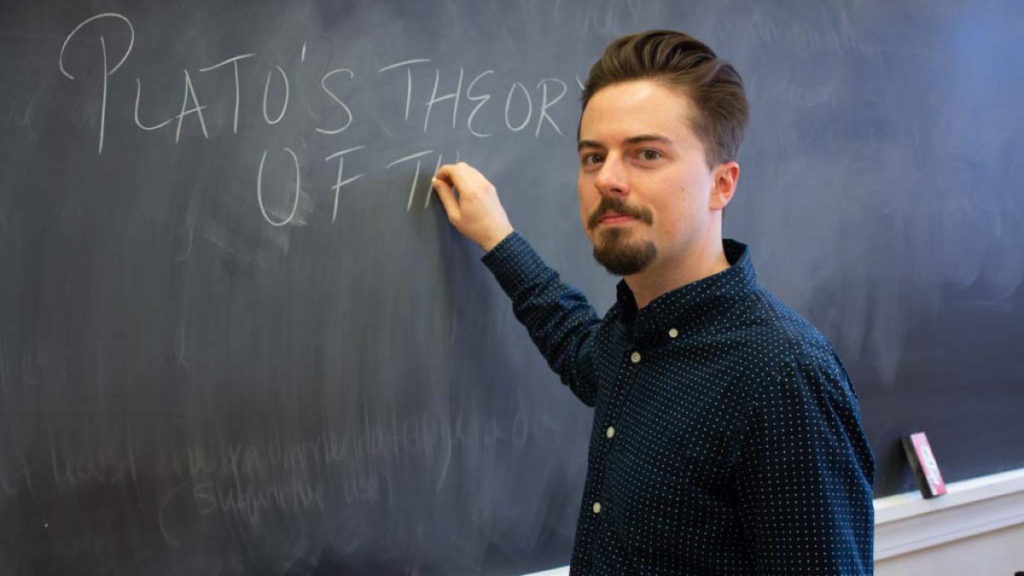 Philip Bold at the chalkboard writing the words "Plato"