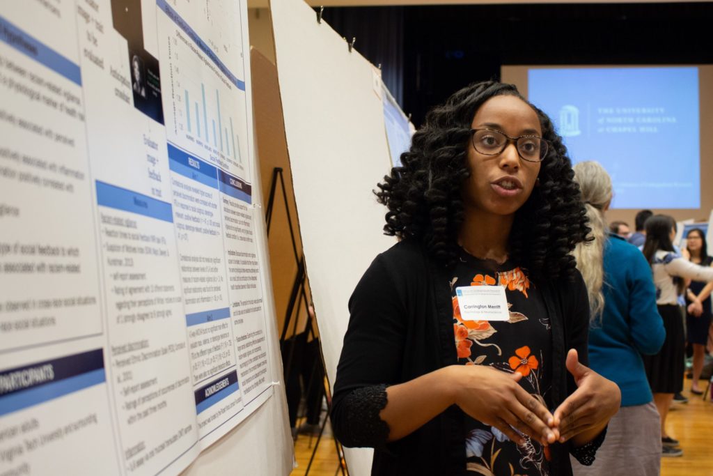 (photo from the 2018 Celebration of Undergraduate Research by Kristen Chavez) Photo shows a student presenting her poster.