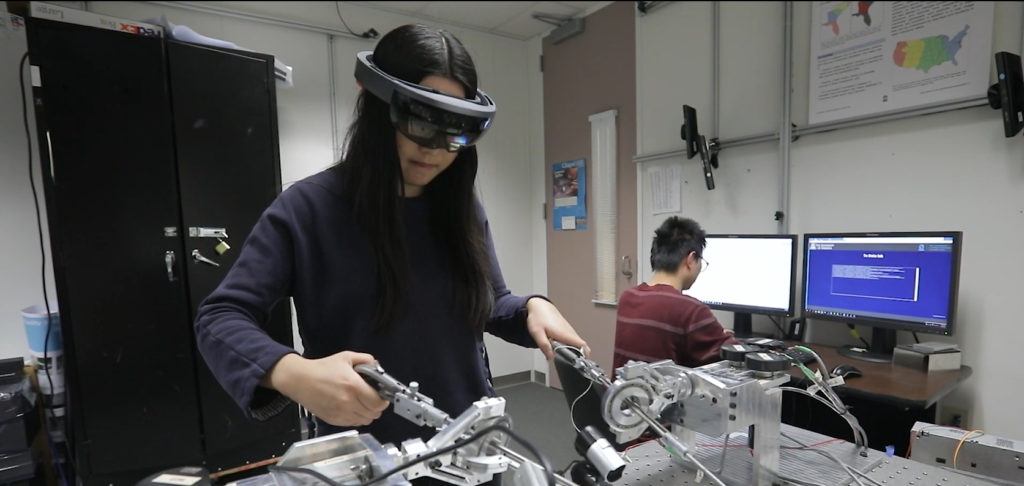 A student uses equipment while wearing a VR headset.
