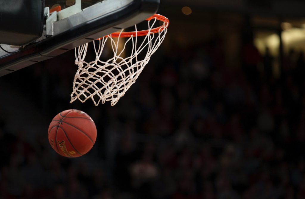 Photo of a basketball going through a hoop by Markus Spiske of Unsplash