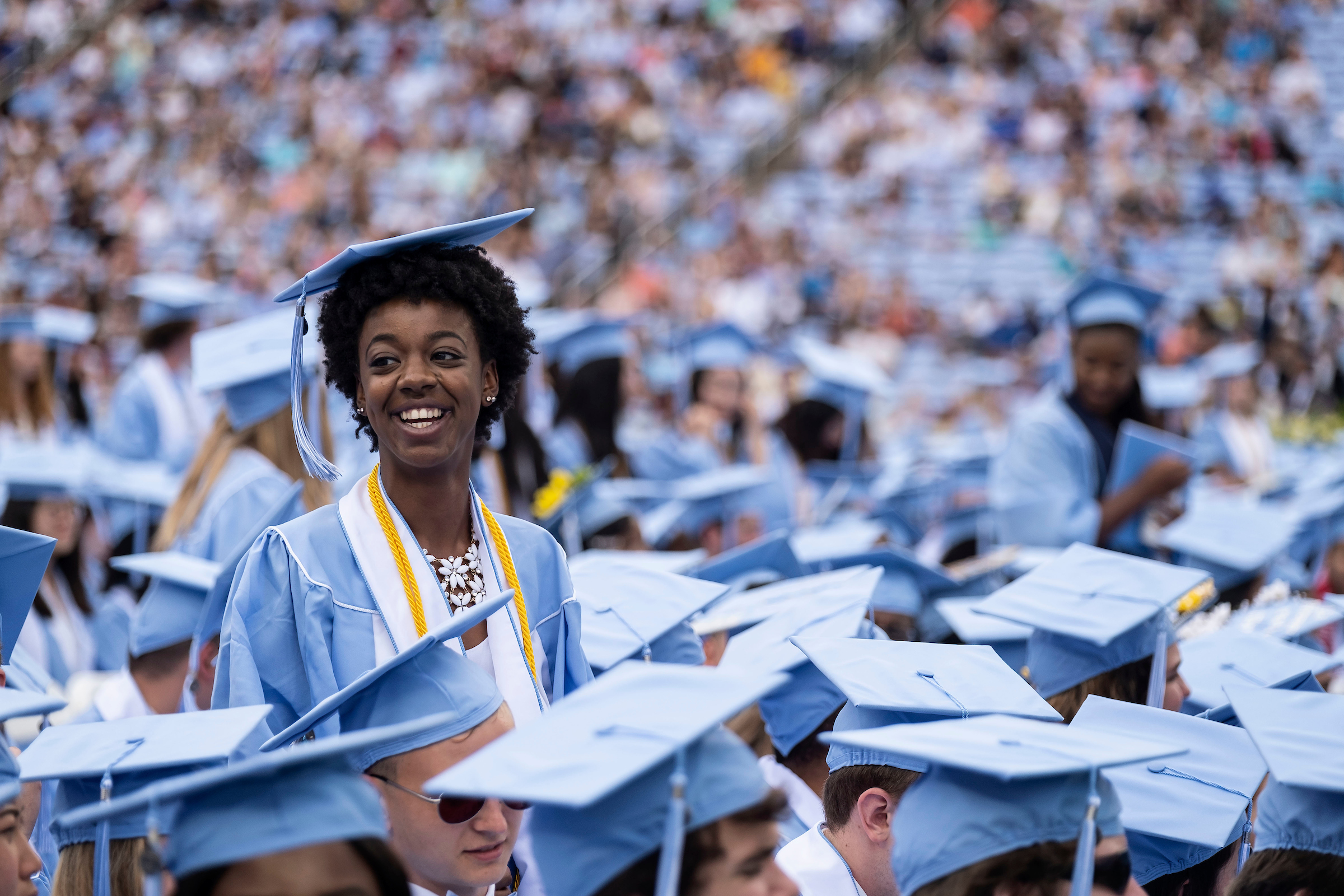 The University of North Carolina at Chapel Hill celebrates the graduation of more than 6,000 students at the annual Spring Commencement May 12, 2019 at Kenan Memorial Stadium. Interim Chancellor Kevin M. Guskiewicz presided over the ceremony, which marked the graduation of 3,944 undergraduates, 1,244 masters students, 258 doctoral students and 588 professional students. Jonathan Reckford, 1984 Carolina alumnus and CEO of Habitat for Humanity, delivered the keynote address. (Jon Gardiner/UNC-Chapel Hill)A graduate smiles in a sea of Carolina blue at the 2019 Commencement ceremonies on May 12. (photo by Jon Gardiner)