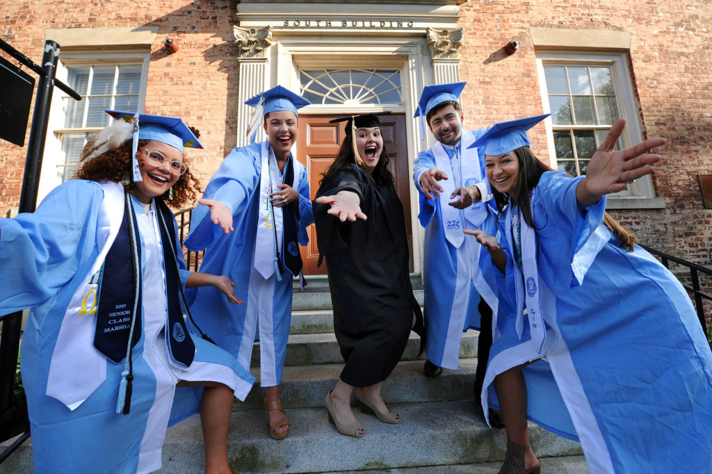 Victoria Chavis (center) celebrates with from left to right: Emily Chavis, Gabrielle James, Dylan Brooks and Kennedy Locklear. (photo by Donn Young). In caps and gowns, they throw their caps in the air on South Building steps.