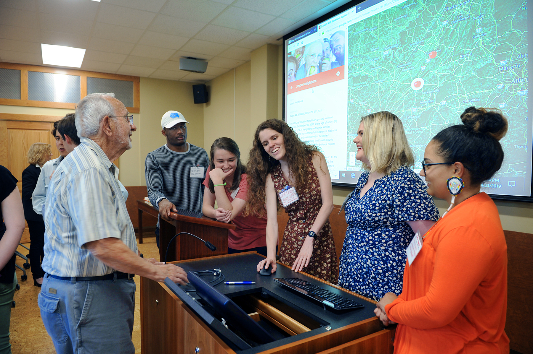 Lee Calhoun discusses the students' projects with them at a celebration at Wilson Library. (photo by Donn Young)