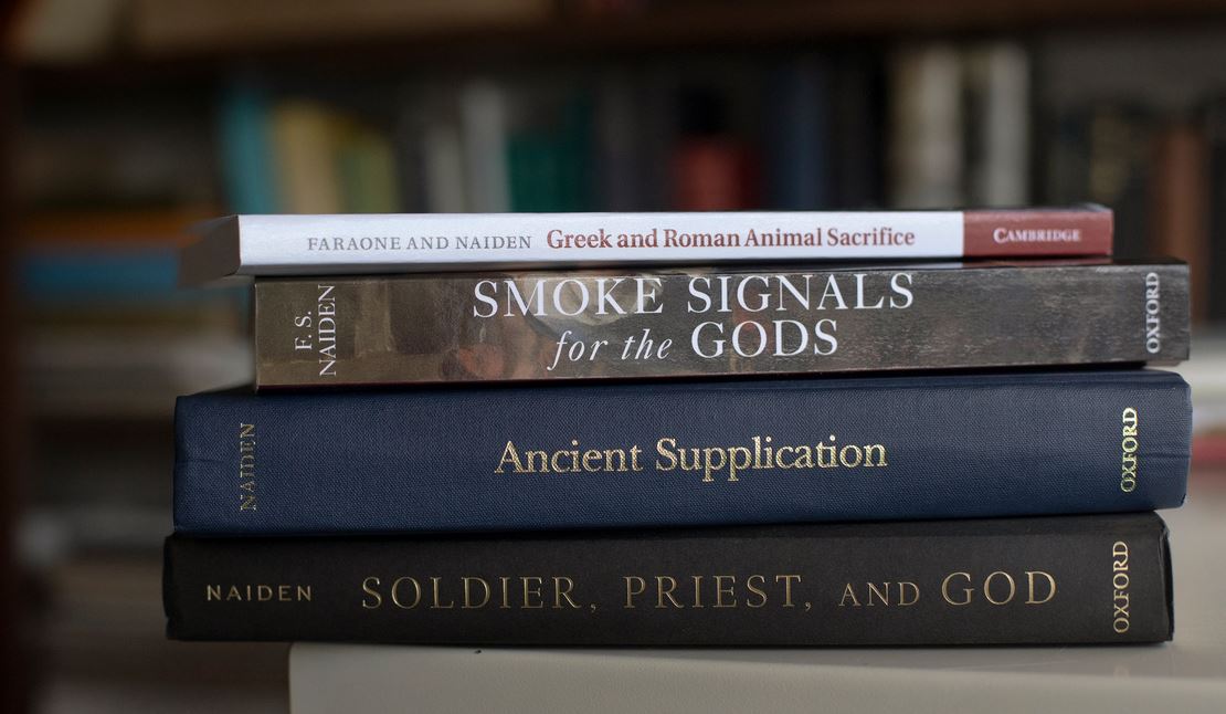 Naiden's previous books cover traditions in ancient Greek and Roman culture. (photo by Megan May). This photo shows a stack of books.
