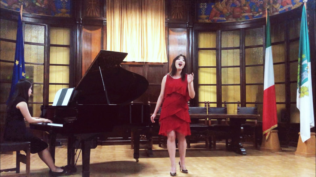 Melody Zhuo sings opera, accompanied by a pianist, on stage in Italy as part of the Si Parla, Si Canta program, which trains young musicians in Italian language, repertoire, culture and musical style.