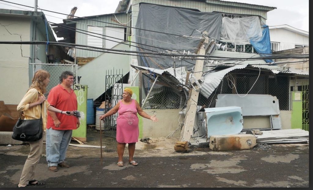 Smith-Nonini interviews Hiram Rosario, who stands in front of her home in San Juan.