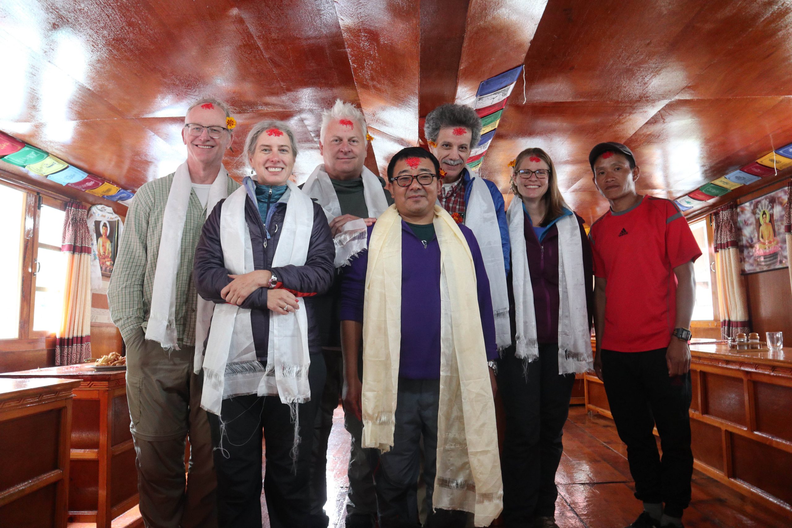 The Carolina research group with their guides celebrating a Nepali national holiday on the second day of the trek. (The red mark on their foreheads, tika, is a blessing ritual). From left, Harvey Seim, Lauren Leve, Rich McLaughlin, guide Deep Rai, Roberto Camassa, Emily Eidam and guide Daman Rai. (photo courtesy of Emily Eidam).