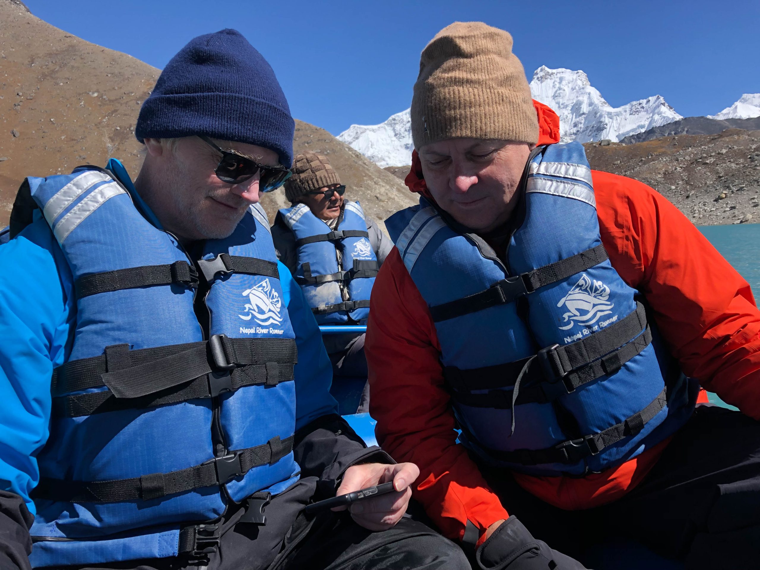 Seim and McLaughlin examining lake depth data. (photo by Emily Eidam) Closeup of the two men in the boat with warm hats and vests and other gear